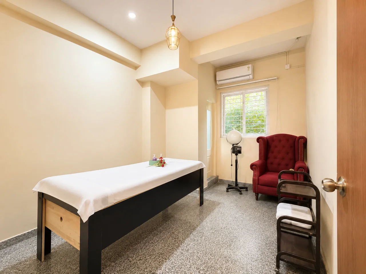 Macau Spa and Salon treatment room with a treatment bed, red chair and soft lighting